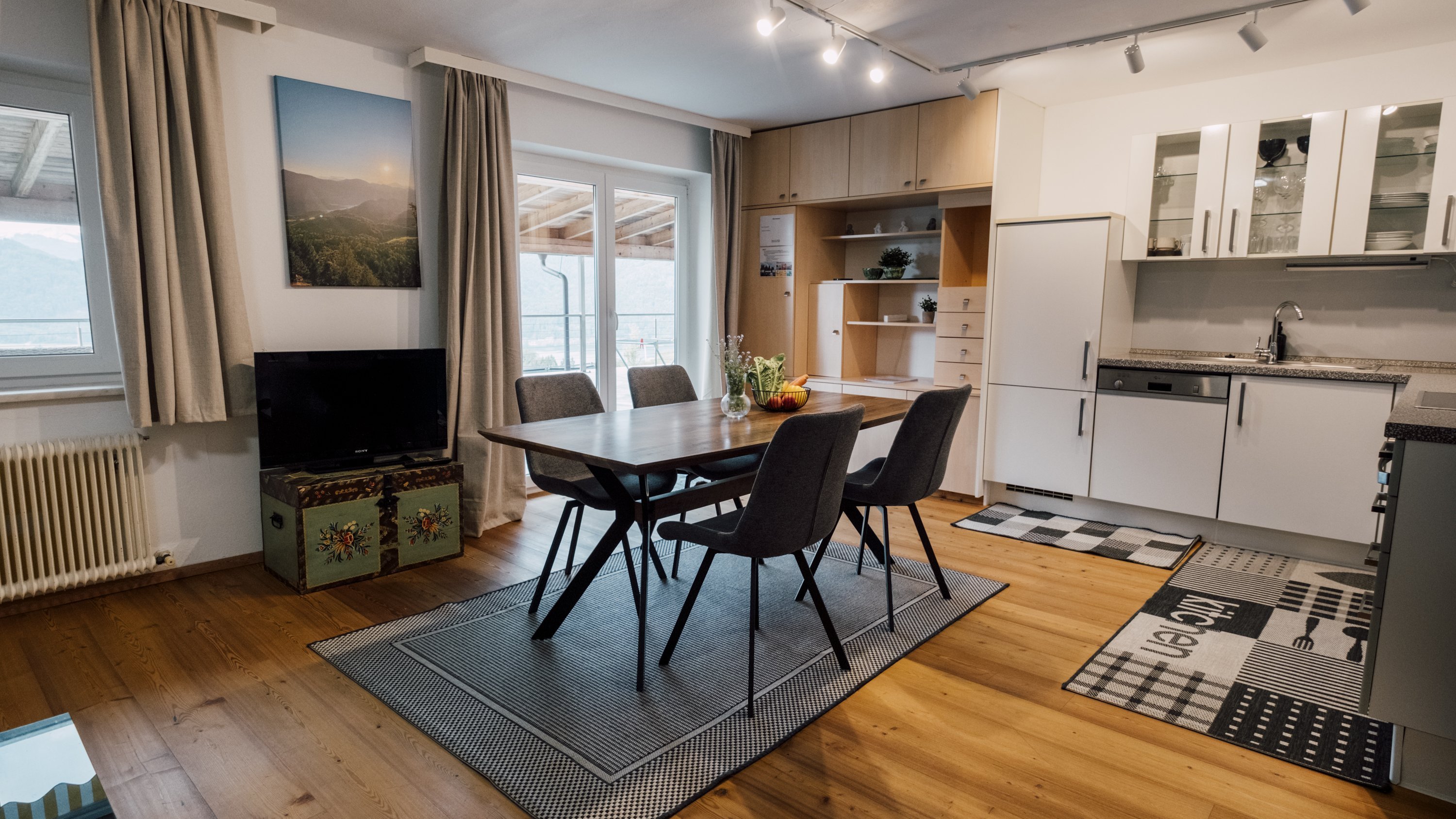 Moderner Küchen- und Essbereich mit Holztisch und Stühlen in einem stilvollen Interieur