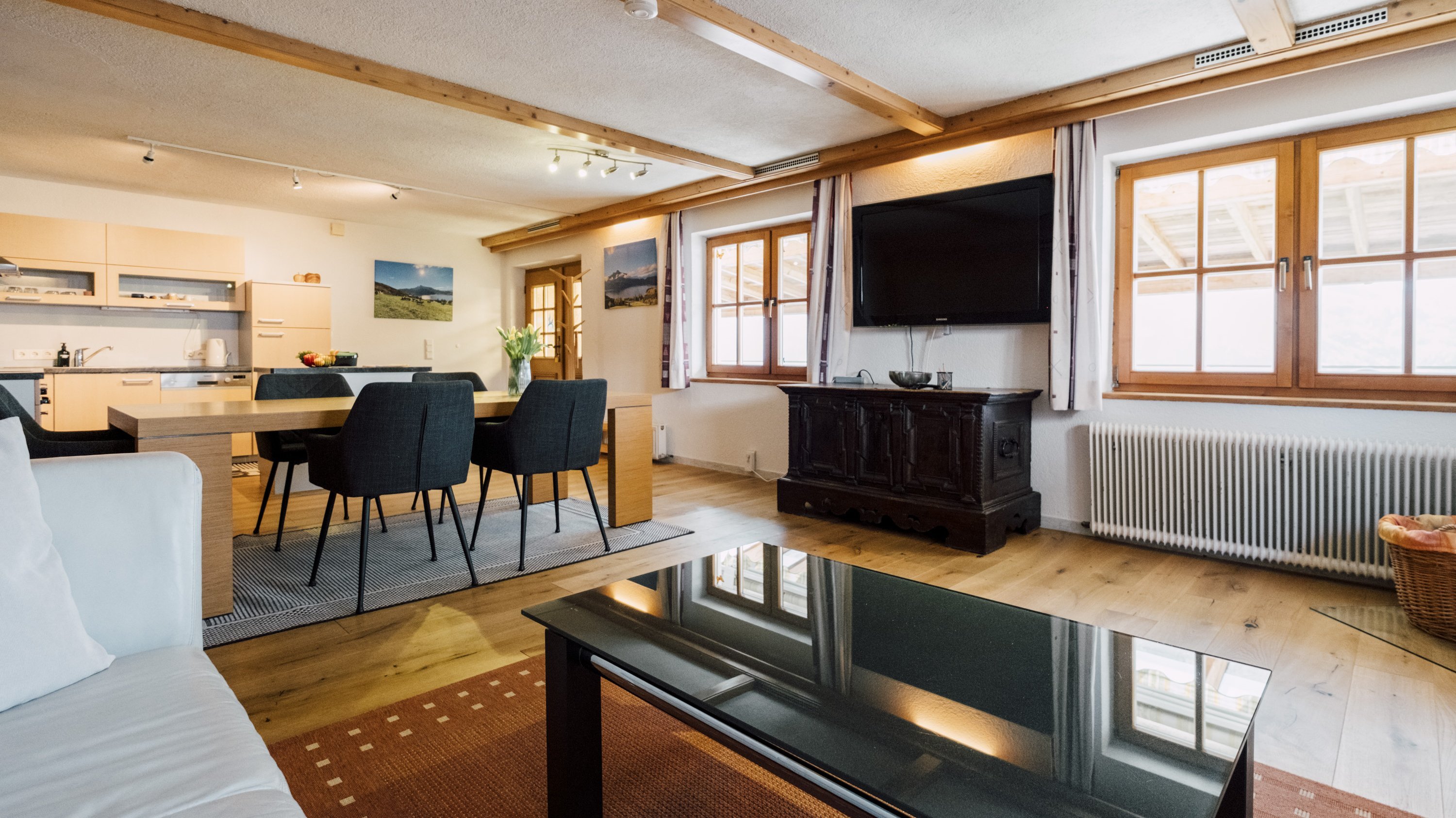 Helles Wohnzimmer mit Essbereich, Holzdecken und großen Fenstern für Tageslicht.