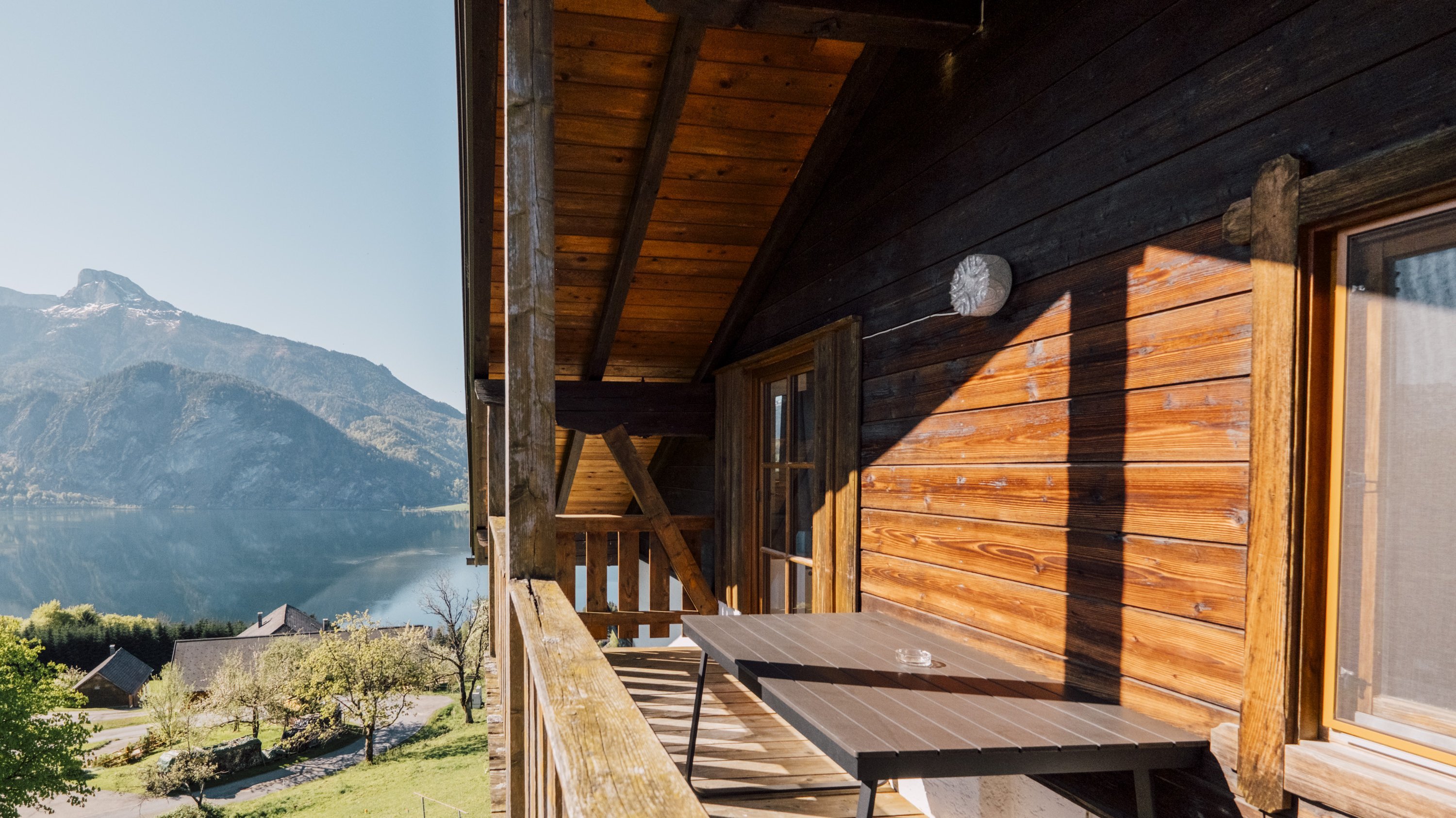 Holzveranda mit Blick auf den Mondsee und die umliegenden Berge, ideal für Entspannung.