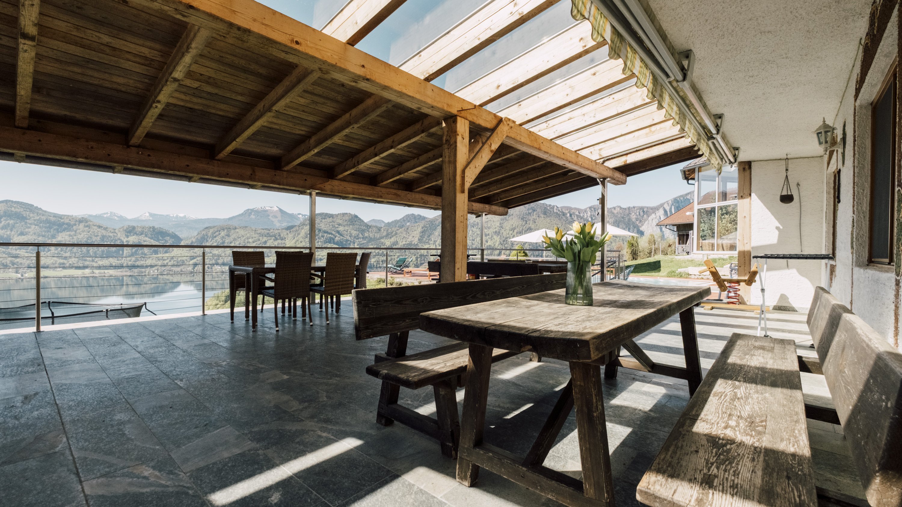 Terrasse mit Holzmöbeln und Blick auf die Berge im Hintergrund, ideal zum Entspannen