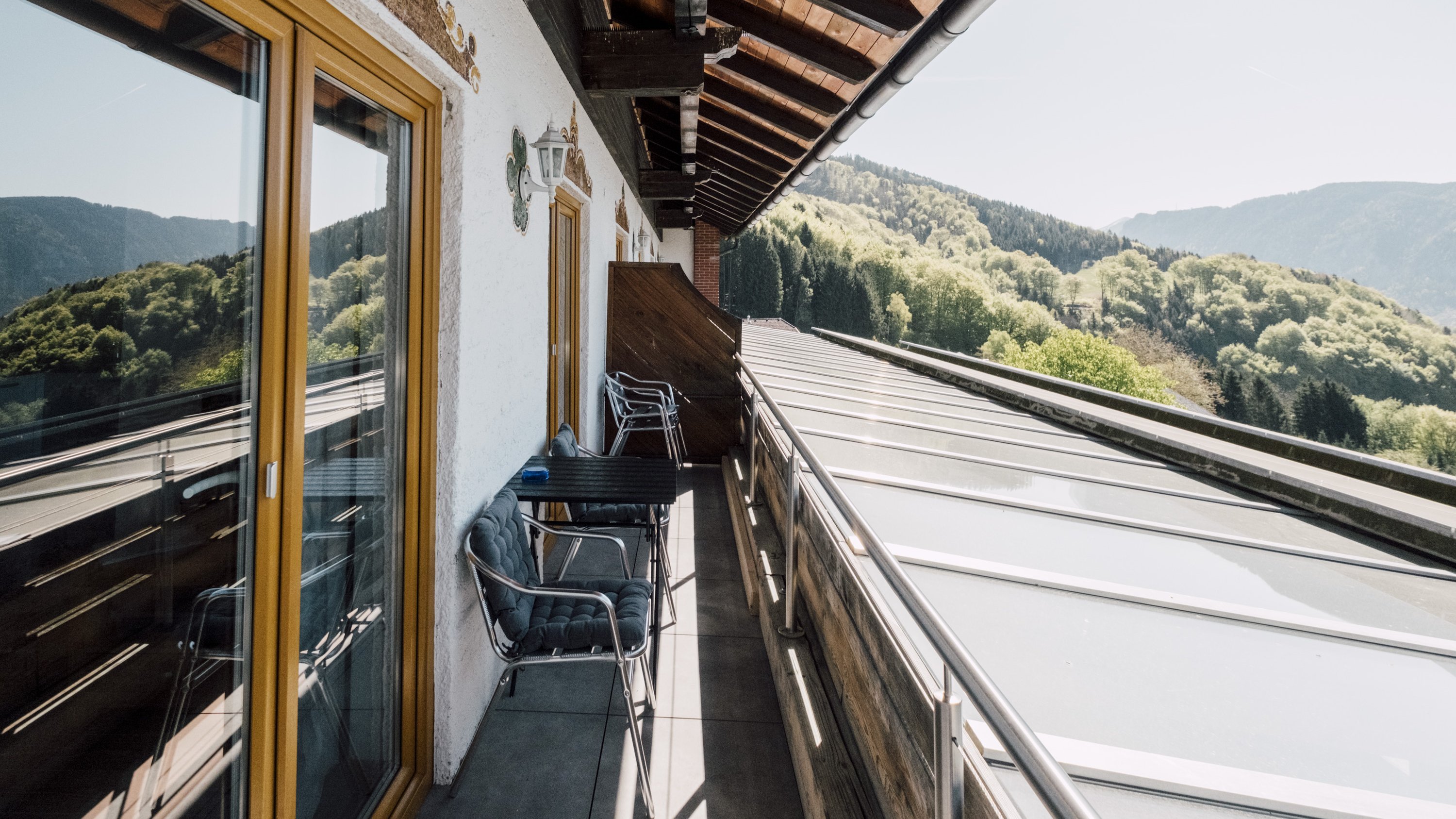 Balkon mit Sitzgelegenheiten und Blick auf die Berge und die Natur im Hintergrund