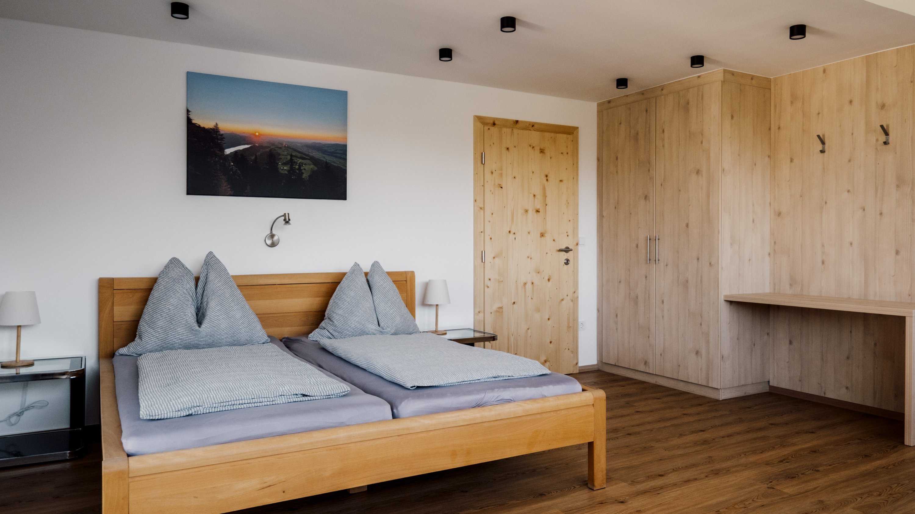 Ein modernes Schlafzimmer mit einem Holzbett und minimalistischem Dekor im Hintergrund.